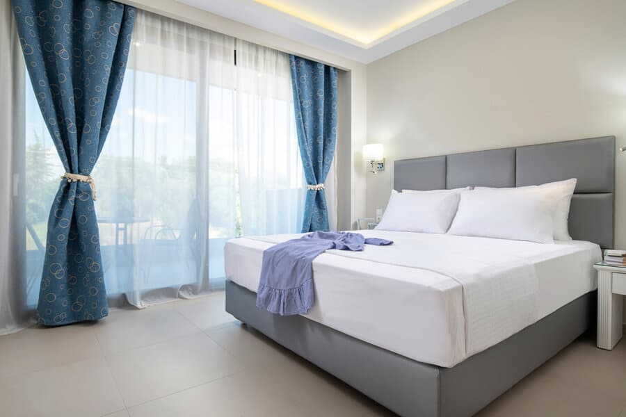 Elegant bedroom with blue patterned curtains and sheer drapes