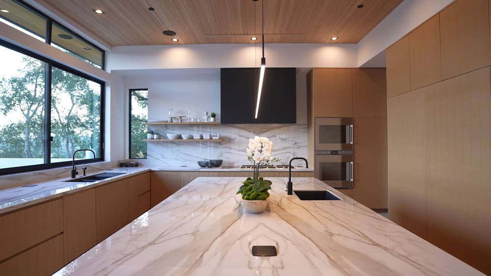 Minimalist Kitchen Island Pendant Lighting Ideas 2 Streamlined kitchen with wood tones and linear pendant light