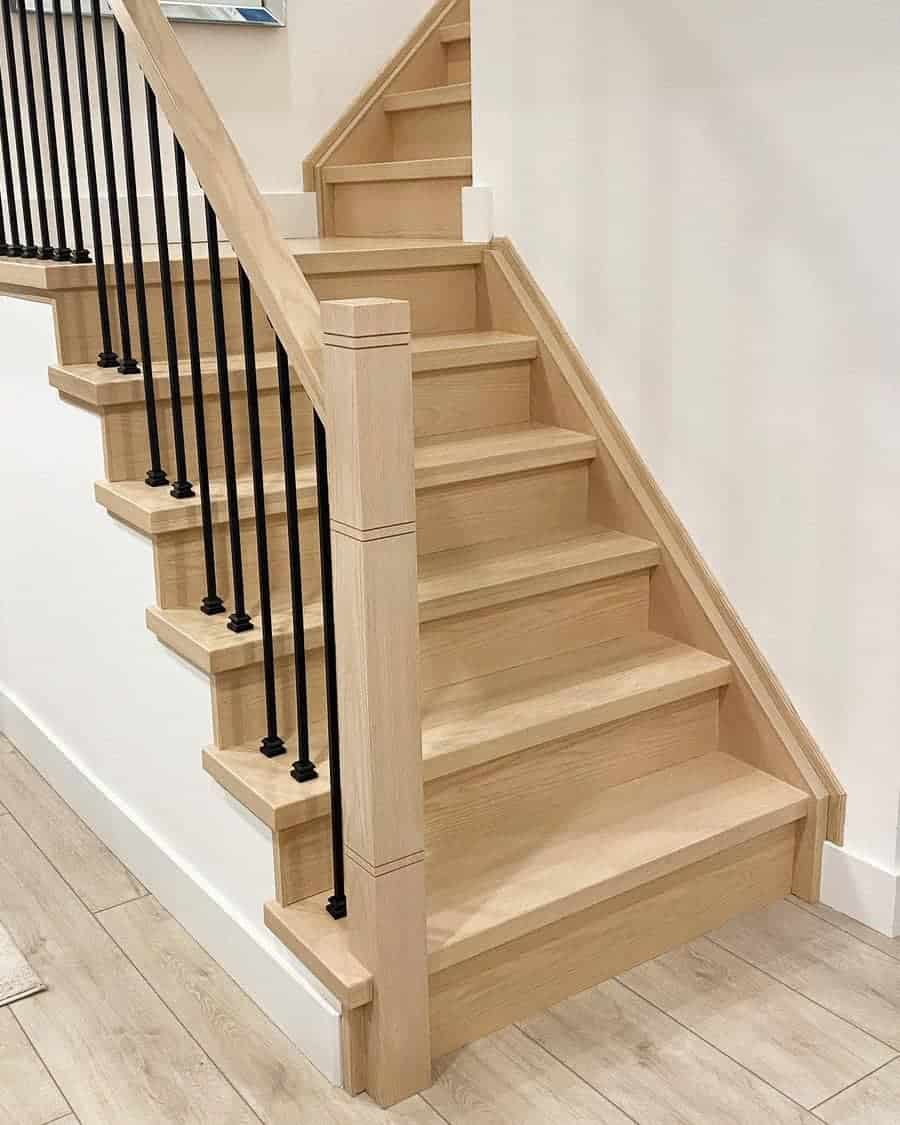 Metal and wooden staircase with white wall